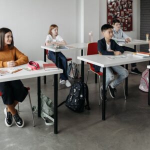 Diverse group of students learning attentively in a bright classroom setting.